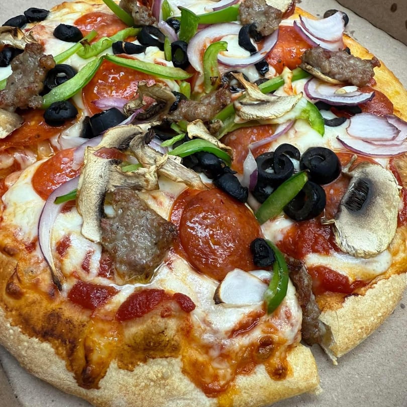 Rego's Brickhouse Pizza with pepperoni, sausage, mushrooms, olives, green peppers, and red onions.